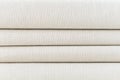 Stack of folded beige woven fabric patterned background