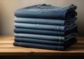 Stack of folded blue denim jeans on wooden surface Royalty Free Stock Photo