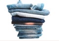 Stack of folded clothes, blue jeans pants, dark blue denim trousers on white background Royalty Free Stock Photo