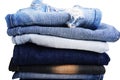 Stack of folded clothes, blue jeans pants, dark blue denim trousers on white background Royalty Free Stock Photo