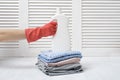 Stack of folded clothes and detergent bottle in female hand. Housework Royalty Free Stock Photo