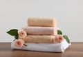 Stack of folded colorful towels with roses on wooden table Royalty Free Stock Photo