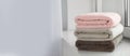 Stack of folded colorful towels on windowsill indoors, space for text. Banner design Royalty Free Stock Photo