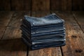 A stack of folded denim jeans rests on a rustic wooden surface, showcasing their rich textures and colors Royalty Free Stock Photo