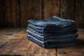 A stack of folded denim jeans rests on a rustic wooden surface, showcasing their rich textures and colors Royalty Free Stock Photo