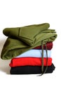 Stack of folded hoodie and hooded sweatshirts on white background. Trendy comfortable casual clothes. Closeup. Vertical