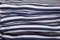 Stack of folded and ironed striped T-shirts close up