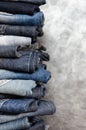 A stack of folded jeans on gray background. Close-up of jeans in different colors. Denim background. Copy space Royalty Free Stock Photo