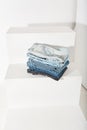 a stack of folded jeans lies on a white stepped podium close-up. online shopping Royalty Free Stock Photo