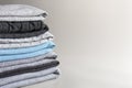 Stack of folded knitted clothes on a gray background with place for text