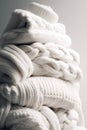 a stack of folded light knitted sweaters on a light background