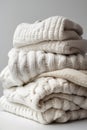 a stack of folded light knitted sweaters on a light background