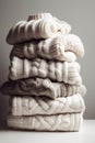 a stack of folded light knitted sweaters on a light background