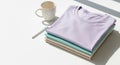Stack of Folded Pastel Colored T-shirts with Coffee Mug on White Surface Royalty Free Stock Photo