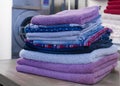 Stack of folded pastel colors clothes in a laundry. Clean and soft clothes pile