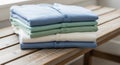 Stack of folded polo shirts placed on a wooden bench, featuring light blue, green, and Royalty Free Stock Photo
