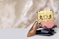 A stack of folded sweaters, a pair of jeans and a trendy yellow handbag on top and a elegant brown shoe on table over bright Royalty Free Stock Photo