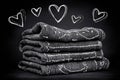 Stack of folded towels with heart doodles on chalkboard background Royalty Free Stock Photo