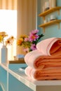 Stack of folded towels sitting on top of bathroom counter next to vase of flowers. Generative AI Royalty Free Stock Photo