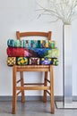 Stack of folded traditional quilts on wooden chair, floor lamp Royalty Free Stock Photo