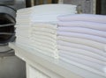 Stack of folded white fabrics, bed sheets, tablecloths in an industrial laundry Royalty Free Stock Photo