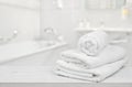 Stack of folded white spa towels over blurred bathroom background Royalty Free Stock Photo