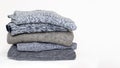 Stack of folded woolen knitwear on white background. Season of warm knitted clothes: sweaters, jumpers, cardigans Royalty Free Stock Photo