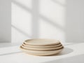 A stack of four beige ceramic plates on a white surface. Royalty Free Stock Photo