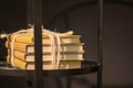 A stack of four books tied with a rope and lying on a shelf in a wooden bedside table. Royalty Free Stock Photo