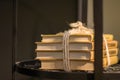 A stack of four books tied with a rope and lying on a shelf in a wooden bedside table. Royalty Free Stock Photo