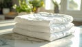 Stack of four folded white comforters on marble countertop in bright room Royalty Free Stock Photo