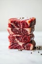 Stack of Four Premium Raw Beef Steaks with Salt and Pepper Royalty Free Stock Photo