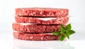 Stack of Four Raw Ground Beef Patties with Fresh Basil Sprig on White Background burger Royalty Free Stock Photo