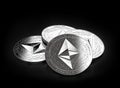 Stack of four silver Ethereum Classic ETC coins laying on the black background