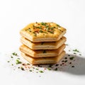 A stack of four square crackers topped with herbs and spices on a white surface Royalty Free Stock Photo