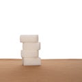 Stack of four sugar cubes on fabric, white background. Healthy eating. Royalty Free Stock Photo