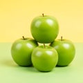 Stack of Four Vibrant Green Apples on a Split Yellow and Green Background Royalty Free Stock Photo