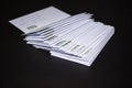 Stack of franked letters in white envelopes on black background