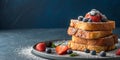 Stack of french toast with berries and powdered sugar on a gray plate surface Royalty Free Stock Photo