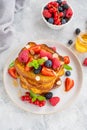 A stack of French toast on a plate with fresh berries, almond petals and honey on a gray concrete background. Delicious breakfast Royalty Free Stock Photo