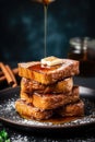 A stack of french toast with syrup being drizzled on top. Generative AI image.