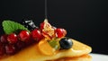 Stack of fresh fluffy pancakes decorated on top with forest berries on plate and pouring honey syrup. Delicious, healthy