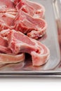 Stack of fresh lamb loin chops. Close up. Meat industry. The product is on a metal tray, Butcher craft