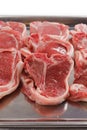 Stack of fresh lamb loin chops. Close up. Meat industry. The product is on a metal tray, Butcher craft