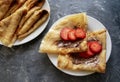 Stack of fresh thin pancakes with chocolate paste and strawberry on gray background Royalty Free Stock Photo