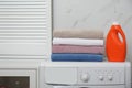 Stack of fresh towels and detergent on washing machine in room Royalty Free Stock Photo
