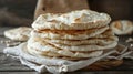 Stack of freshly baked flatbread on a wooden surface