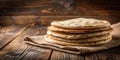 A stack of freshly baked flatbreads rests on a rustic wooden surface, covered with a burlap cloth, showcasing the golden-brown Royalty Free Stock Photo