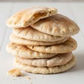 A stack of freshly baked pita breads is displayed on a white surface. The breads are Royalty Free Stock Photo