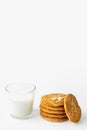 Stack of freshly home baked oatmeal and coconut biscuits glass of milk on white kitchen table wall background. Australian anzac